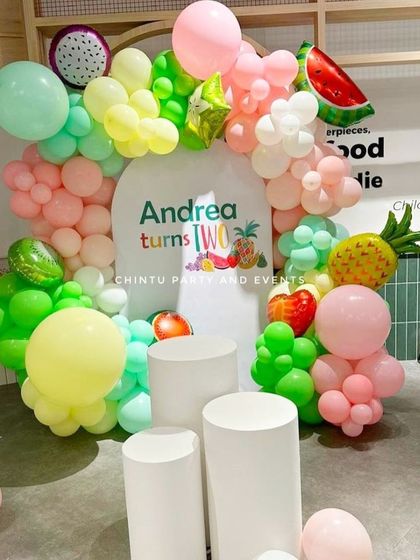A "Two-tti Fruity" fruits-themed second birthday party. The colorful balloon ring is decorated with various fruit-shaped foil balloons for a fresh and fun look.