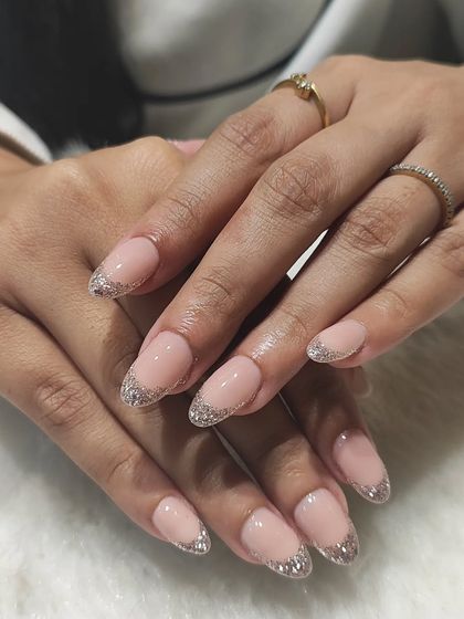 A simple yet sophisticated look. These short, almond-shaped nails feature a classic French tip outlined with a fine line of silver glitter, proving that elegance is all in the details.
