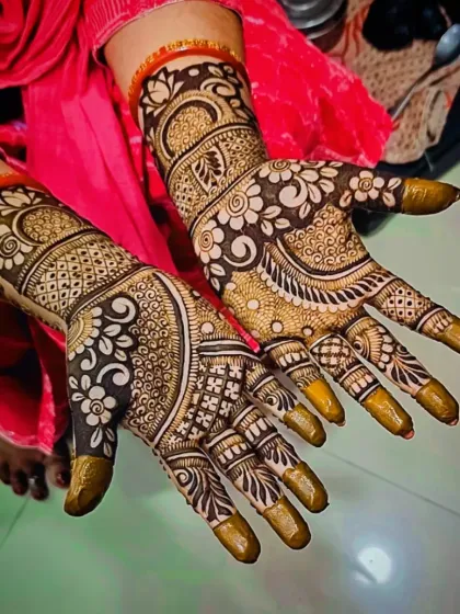 A gorgeous, dense mehandi design with bold floral work and intricate checks, perfect for any festival. The tips are covered for a dark stain.