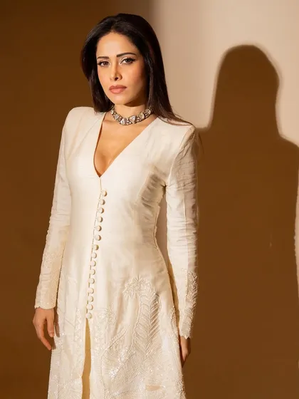 This ivory kurta and flared pants set on Nushrratt Bharuccha is all about classic elegance. The delicate embroidery and button details make it a timeless piece for any special occasion.