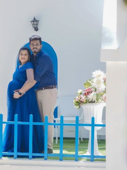 A sweet couple's portrait at the Santorini set. The blue fence and flowers in the foreground add depth and visual interest to the shot.