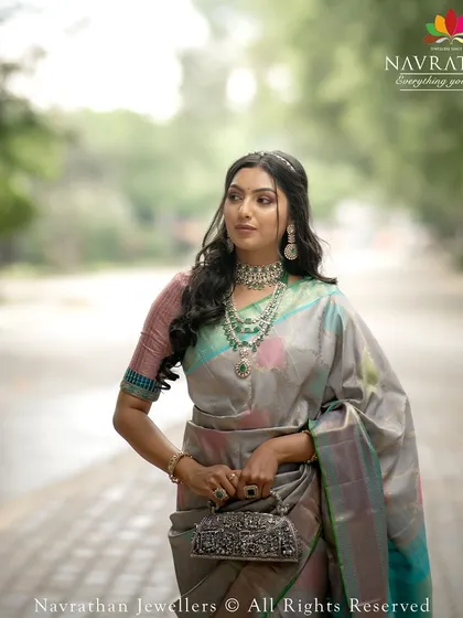 This model showcases a stunning multi-tonal Kanchipuram silk saree, paired with exquisite emerald and polki jewelry.