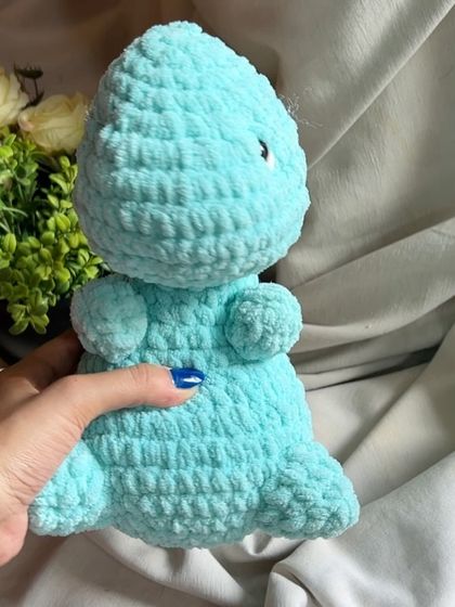 A side profile of our chunky yarn dinosaur, showing its simple and cute design. It's made to be durable for hours of play.