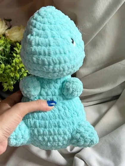 A side profile of our chunky yarn dinosaur, showing its simple and cute design. It's made to be durable for hours of play.