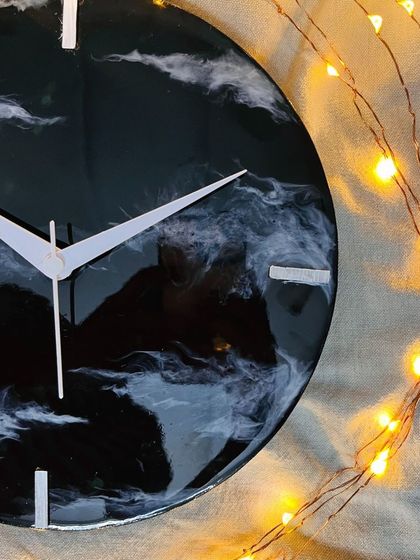 A close-up of a finished galaxy resin clock, with fairy lights adding a magical glow. This shows the beautiful decor you can create.