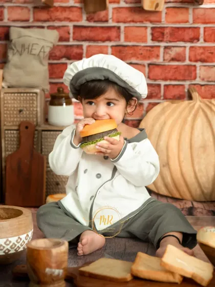 This little chef is taking a break to enjoy a toy burger. These playful moments make for the best photos.