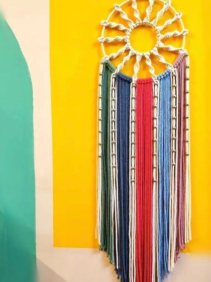 A vibrant, sun-shaped dreamcatcher with a multi-colored fringe. This piece is perfect for adding a pop of color and bohemian flair to any wall.