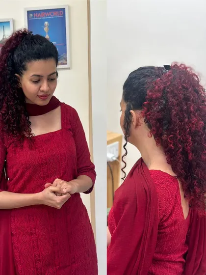 For this client, we embraced her beautiful natural curls with a fiery red balayage. The deep red tones are painted on to enhance the texture and volume of her hair, creating a bold yet elegant look, shown here styled in a high ponytail and also worn down.