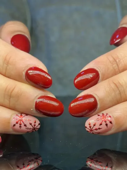 A full view of the festive red and snowflake nail art.