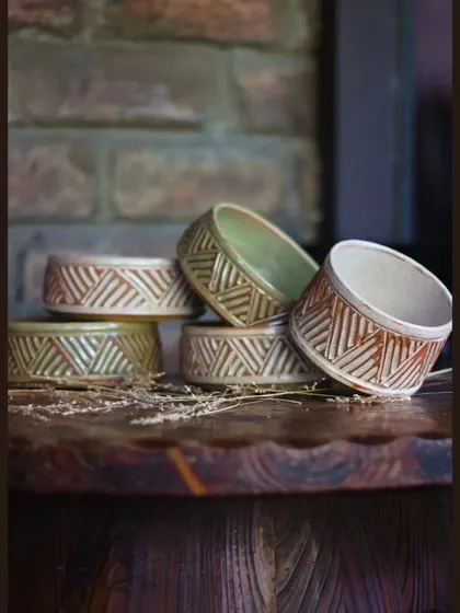 A stack of carved bowls from the KHUMĀR collection. These are perfect for serving nuts, dips, or other snacks during a get together.