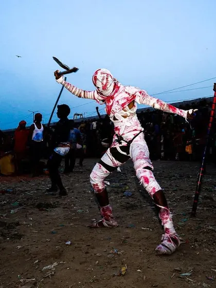 A devotee in a striking white and red costume dances during the Gajan festival, a whirlwind of motion and tradition.