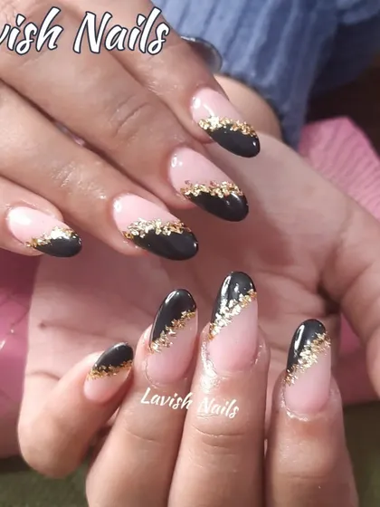 A chic design with black diagonal tips on a nude base, separated by a line of gold foil flakes.