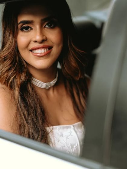 A beautiful portrait of the bride smiling from the wedding car.