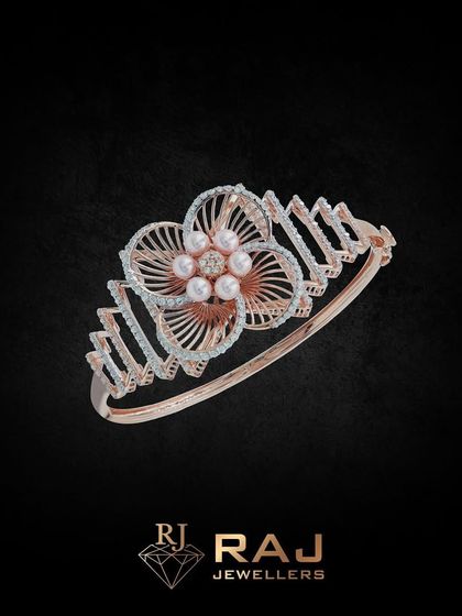 This floral-inspired kada features a large, open-petal flower with pearl accents at its center. The band has a modern, angular design, creating a beautiful contrast of styles.