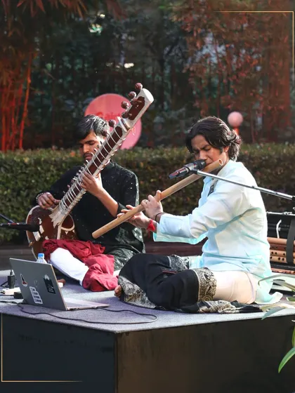 Two musicians performing a duet with a sitar and a flute. This image captures the soul of our cultural events, where traditional Indian classical music fills the air.