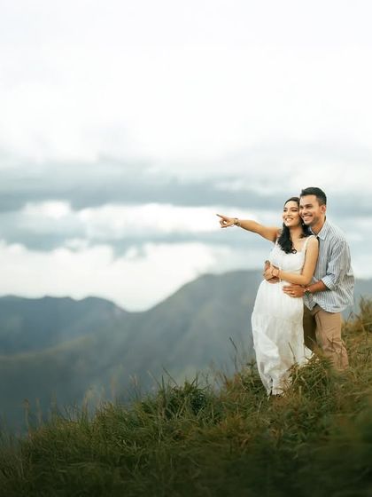 Gazing toward the horizon together. This pre-wedding photo captures a sense of shared dreams and future plans, set against the breathtaking beauty of a mountain landscape.