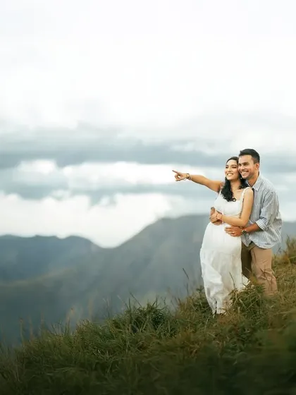 Gazing toward the horizon together. This pre-wedding photo captures a sense of shared dreams and future plans, set against the breathtaking beauty of a mountain landscape.