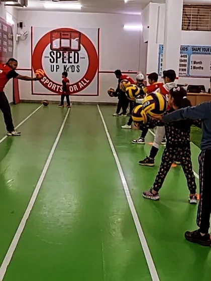 "Where fun meets fitness." A group of kids learning ball handling skills with their coach.
