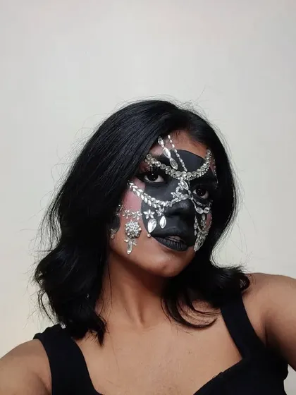 For this look, I created a mask-like effect using black face paint and embellished it with silver rhinestones and jewelry pieces.