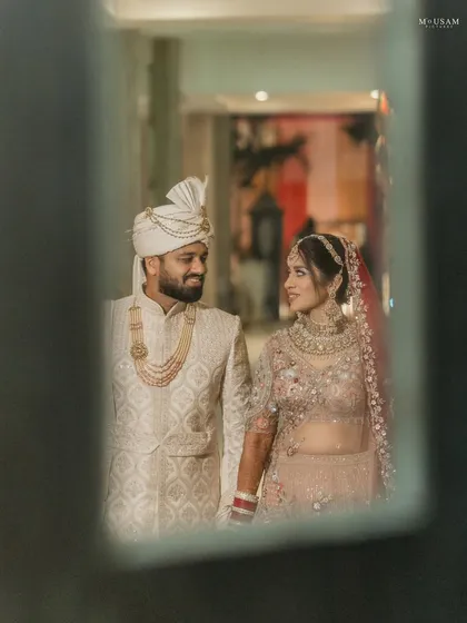 A stolen moment, captured through a reflection. The couple shares a look of love and admiration, a quiet conversation that no one else is a part of. These creative frames add a layer of artistry to your story.