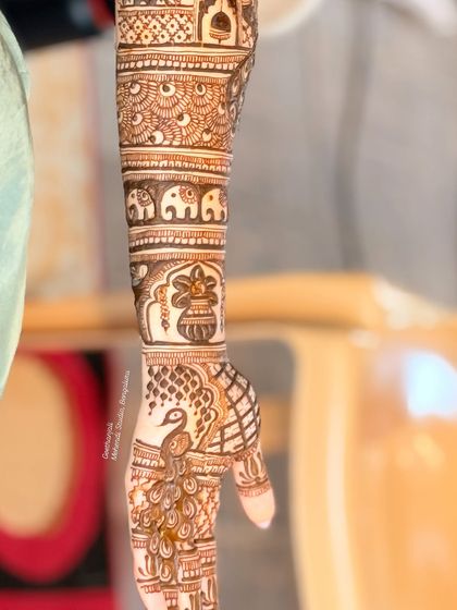 A view of the forearm, showing the elephant and kalash motifs.