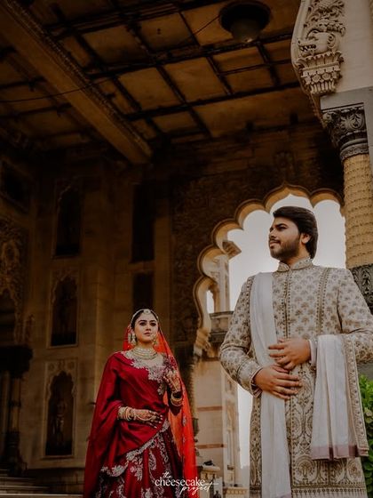 An artistic shot of the couple framed by the grand arches of the palace.