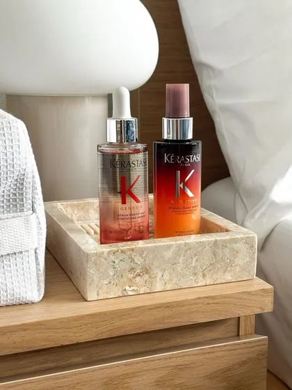 The Kérastase serums displayed in a marble tray, emphasizing the luxury and quality of the products we offer.