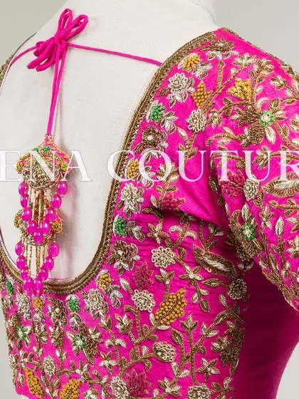 This bright pink raw silk blouse is a showcase of exquisite craftsmanship. The sleeves and back are covered in dense, multi-colored floral handwork, and I added beautiful custom tassels with bead detailing to complete the look.
