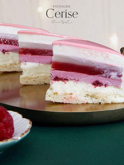 Slices of the "Explosion of Berries" on a platter, ready to be served. You can clearly see the layers of lychee coulis, strawberry coulis, and raspberry cremeux.