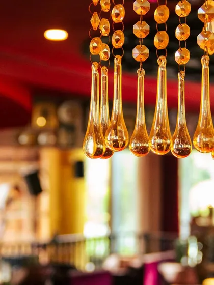 We believe a restaurant is a creative outlet where art and necessity combine. The golden teardrop crystals of this chandelier reflect our commitment to creating a space to socialize, indulge, and connect.