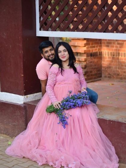 A relaxed outdoor maternity portrait. The soft pink gown and a bouquet of lavender create a gentle and romantic color palette.