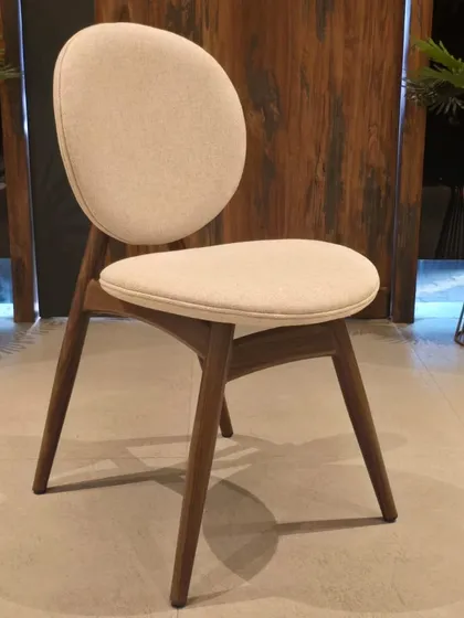 An angled view of the round-back dining chair, showing its simple yet elegant design.