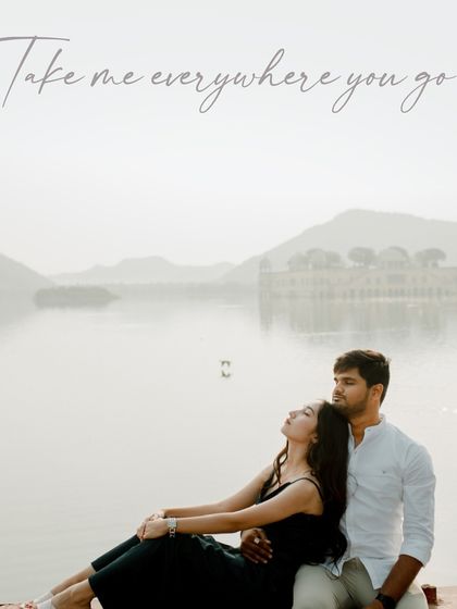 A serene portrait of the couple relaxing by a tranquil lake. The image, with the text "Take me everywhere you go," evokes a sense of shared adventure and peaceful companionship.