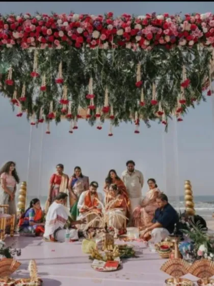 A beach wedding ceremony in progress. I designed this mandap with a hanging floral ceiling, providing a beautiful frame for the family rituals against the backdrop of the sea.