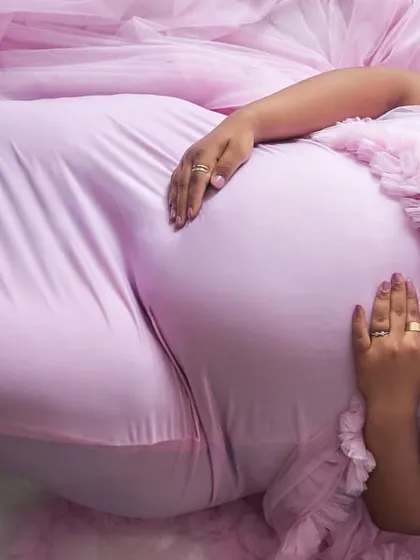 An artistic close-up of the baby bump in our pink Clara gown. The soft, stretchy fabric comfortably hugs your curves.
