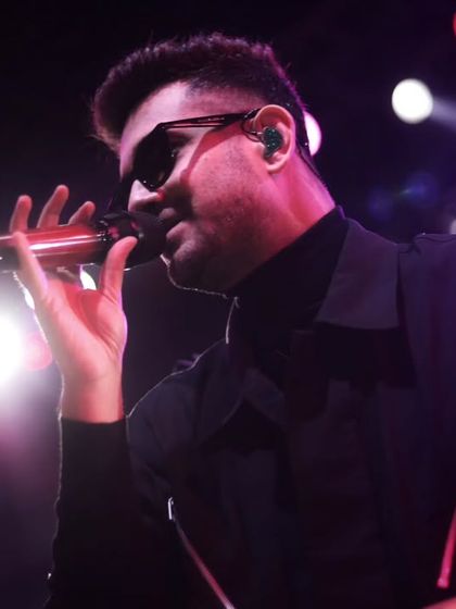 A close-up portrait of the singer, where the stage lights create a soft glow. This intimate perspective brings you closer to the artist's experience on stage.