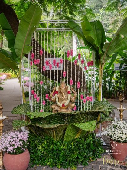 A traditional welcome setup with a Ganesha idol, banana trees, and brass lamps. This arrangement at the entrance immediately sets a sacred and auspicious tone for the wedding celebration.