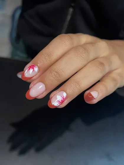 A closer look at the petal details on this elegant French manicure. The hand-painted flowers add a soft, artistic touch.