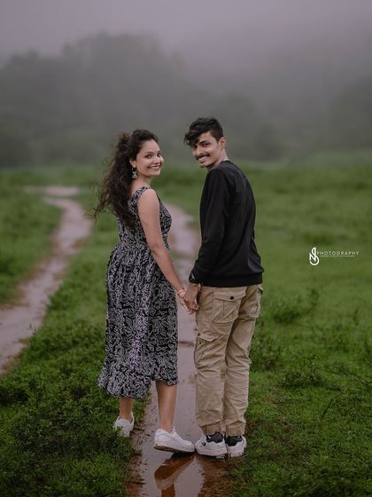 A "follow me" shot on a wet path after the rain. The moody, overcast lighting and lush greenery create a romantic, atmospheric scene.
