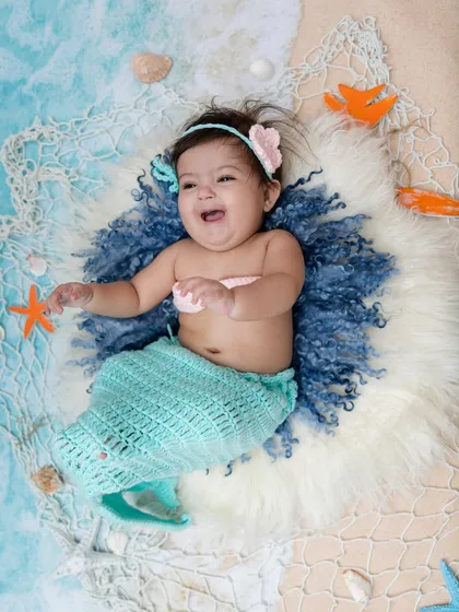 A big, gummy smile from this adorable baby mermaid.