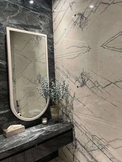 We translated timeless Art Deco vibes into this stunning washroom. Bold black and white marble create a striking aesthetic defined by symmetry, contrast, and elegance.