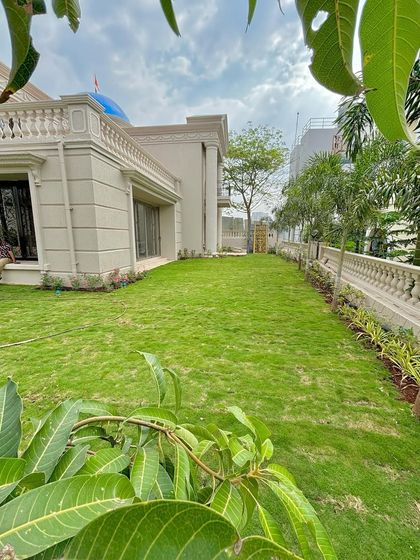 A beautiful view of the completed Thane villa project. The fresh lawn runs alongside a neat border of plants, creating a clean and elegant look for the property.