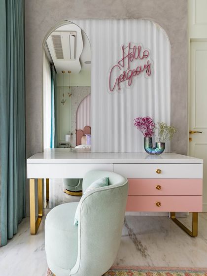 A pastel vanity corner that is both elegant and charming. The design features a 'Hello Gorgeous' neon sign, gold accents, and a mix of pink and mint green for a playful, glam look.