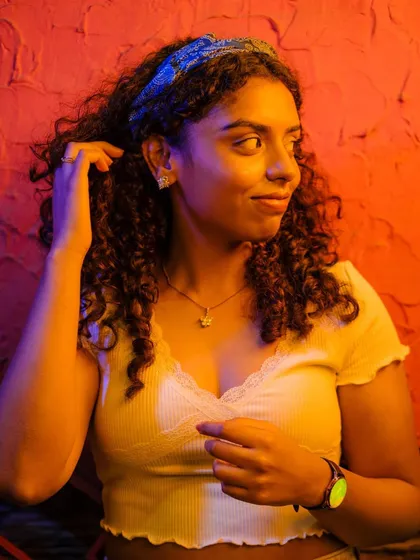 A candid shot of the same woman from the MKT series, looking away from the camera. This image captures a more natural, unposed moment within the stylized, neon-lit environment.