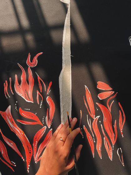 Painting abstract fire patterns on velvet. The way the light hits the fabric adds another dimension to the artwork, making the flames seem to flicker.