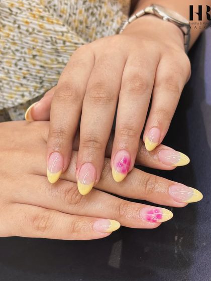A sunny and cheerful design. This look combines a bright yellow French tip with a delicate pink floral accent nail, creating a fresh and feminine manicure that's perfect for summer.