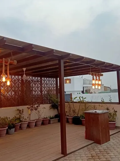 I can transform large terraces into functional outdoor living rooms. For this project, I designed and installed a custom wooden pergola to create a shaded seating and entertainment area, complete with rustic rope lighting and a dedicated bar space.