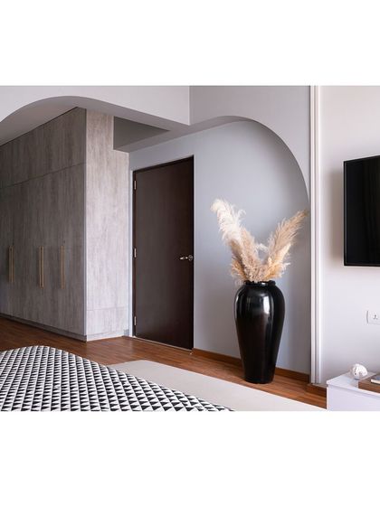 This view shows the other side of the master bedroom, where another arch frames the entrance to the wardrobe area. The use of repeated architectural elements creates a cohesive and harmonious design.