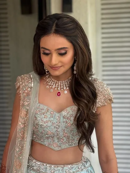 The half-up style keeps hair away from the face while still showcasing its length and volume, making it a practical and beautiful choice for any celebration.