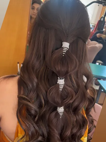 A modern and glamorous take on the half-up style. I created a bubble-effect ponytail with the top section of hair, using sparkling rhinestone cuffs to add a touch of bling. The rest of the hair is styled in voluminous waves.